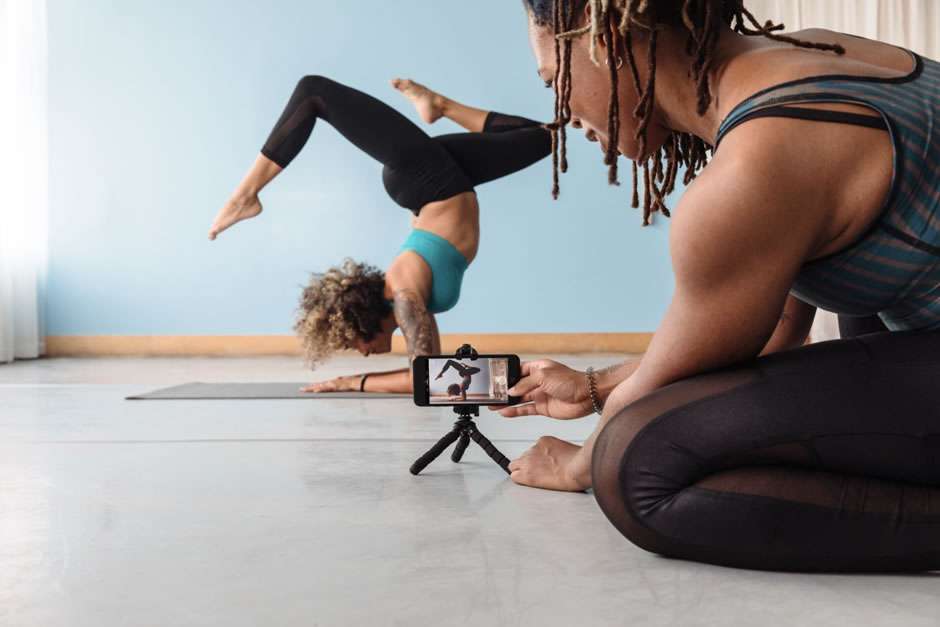 man filming lady doing yoga